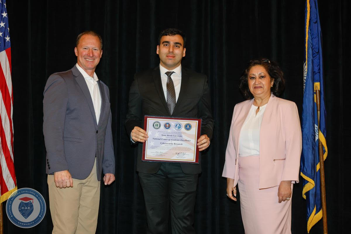 Prof. Amir Rahmati poses with a man and a woman while holding a certificate.