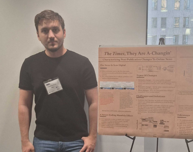 Chris Tsoukaladelis poses next to the winning poster