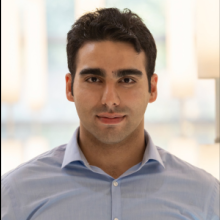 Amir Rahmati: A man with short dark hair and a collared shirt stares into the camera